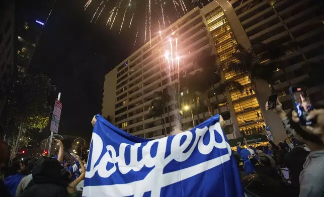 Fireworks go off as fans celebrate on the streets after the Los Angeles Dodgers defeated the New York Yankees to win the baseball World Series Wednesday, Oct. 30, 2024, in Los Angeles. (AP Photo/Ethan Swope)