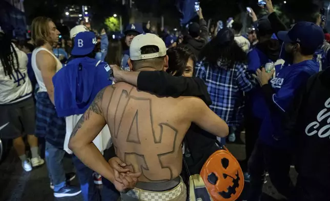 Fans dance while celebrating on the streets after the Los Angeles Dodgers defeated the New York Yankees to win the baseball World Series Wednesday, Oct. 30, 2024, in Los Angeles. (AP Photo/Ethan Swope)