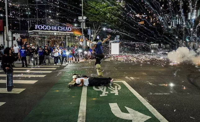 Fireworks go off as fans celebrate on the streets after the Los Angeles Dodgers won against the New York Yankees in the baseball World Series Wednesday, Oct. 30, 2024, in Los Angeles. (AP Photo/Damian Dovarganes)