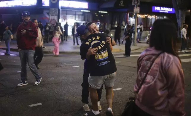 Fans celebrate on the streets after the Los Angeles Dodgers defeated the New York Yankees to win the baseball World Series Wednesday, Oct. 30, 2024, in Los Angeles. (AP Photo/Ethan Swope)