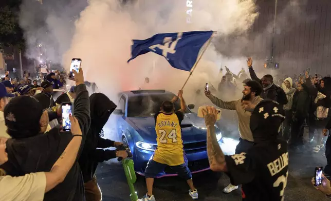 Fans celebrate on the streets after the Los Angeles Dodgers won against the New York Yankees in the baseball World Series Wednesday, Oct. 30, 2024, in downtown Los Angeles. (AP Photo/Damian Dovarganes)