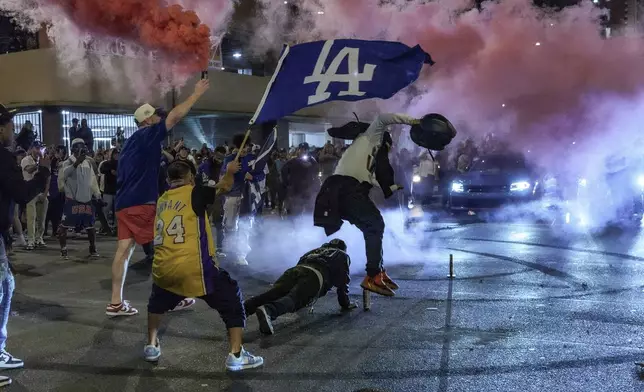 Fans celebrate on the streets after the Los Angeles Dodgers won against the New York Yankees in the baseball World Series Wednesday, Oct. 30, 2024, in Los Angeles. (AP Photo/Damian Dovarganes)