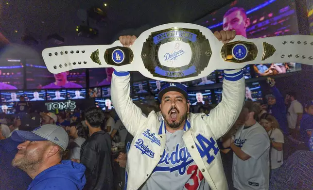 Fans celebrate after the Los Angeles Dodgers defeated the New York Yankees to win the baseball World Series Wednesday, Oct. 30, 2024, in Los Angeles. (AP Photo/Damian Dovarganes)