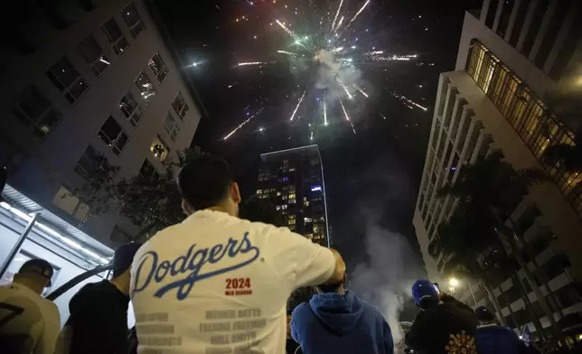 Fireworks go off as fans celebrate on the streets after the Los Angeles Dodgers defeated the New York Yankees to win the baseball World Series Wednesday, Oct. 30, 2024, in Los Angeles. (AP Photo/Ethan Swope)