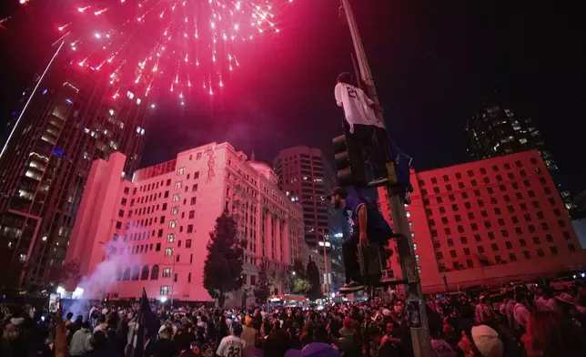 Fireworks go off as fans celebrate on the streets after the Los Angeles Dodgers won against the New York Yankees in the baseball World Series Wednesday, Oct. 30, 2024, in Los Angeles. (AP Photo/Ethan Swope)