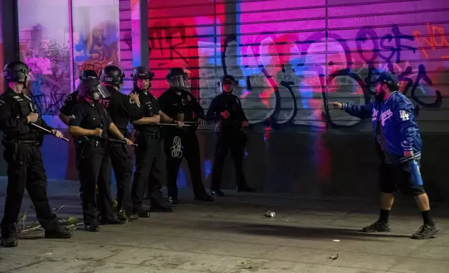 A fan confronts police on the streets after the Los Angeles Dodgers won against the New York Yankees in the baseball World Series Wednesday, Oct. 30, 2024, in Los Angeles. (AP Photo/Ethan Swope)