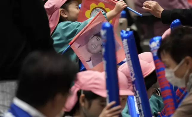 Kindergarteners holding a picture of Shohei Ohtani of the Los Angeles Dodgers watch a live stream before the start of Game 3 of the baseball World Series between the Dodgers and the New York Yankees during a public viewing event in Oshu, northeastern Japan, the hometown of Ohtani, Tuesday, Oct. 29, 2024. (AP Photo/Eugene Hoshiko)