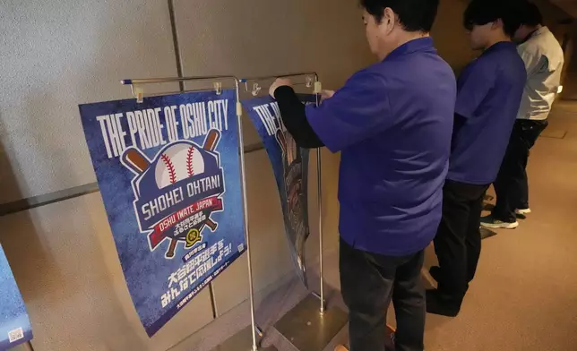 Staff members of a public viewing event for Game 3 of the baseball World Series between the Los Angeles Dodgers and the New York Yankees prepare the venue before the game live stream in Oshu, northeastern Japan, the hometown of Shohei Ohtani of the Dodgers, Tuesday, Oct. 29, 2024. (AP Photo/Eugene Hoshiko)