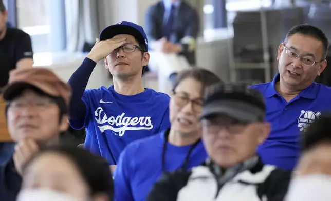 People react as they watch a live view of Game 4 of the baseball World Series between the Los Angeles Dodgers and the New York Yankees during a public viewing event in Oshu, northeastern Japan, the hometown of Shohei Ohtani of the Dodgers, Wednesday, Oct. 30, 2024. (AP Photo/Eugene Hoshiko)