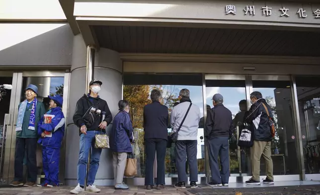 People wait in line to watch a live stream of Game 3 of the baseball World Series between the Los Angeles Dodgers and the New York Yankees, in a public viewing event in Oshu, northeastern Japan, the hometown of Shohei Ohtani of the Dodgers, Tuesday,Oct. 29, 2024. (AP Photo/Eugene Hoshiko)