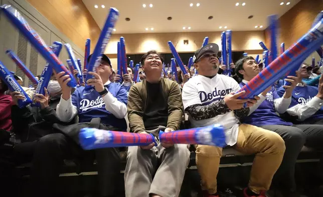 Fans cheer as they watch a live stream of the Game 3 of the baseball World Series between the Los Angeles Dodgers and the New York Yankees during a public viewing event in Oshu, northeastern Japan, the hometown of Shohei Ohtani of the Dodgers, Tuesday, Oct. 29, 2024. (AP Photo/Eugene Hoshiko)