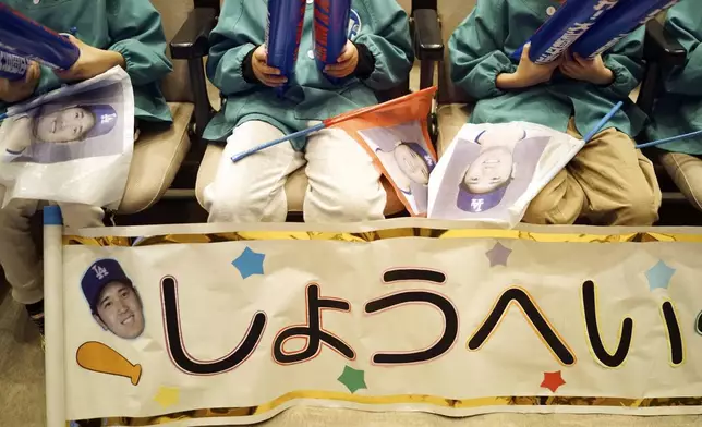 Pupils from Tokiwa Kindergarten where Shohei Ohtani graduated watch on a live stream of Game 3 of the baseball World Series between Los Angeles Dodgers and New York Yankees during a public viewing event in Oshu, northeast of Japan, the hometown of Shohei Ohtani of the Los Angeles Dodgers Tuesday, Oct. 29, 2024. The banner reads "Shohei." (AP Photo/Eugene Hoshiko)