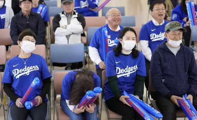 People react as they watch a live view of Game 4 of the baseball World Series between the Los Angeles Dodgers and the New York Yankees during a public viewing event in Oshu, northeastern Japan, the hometown of Shohei Ohtani of the Dodgers, Wednesday, Oct. 30, 2024. (AP Photo/Eugene Hoshiko)