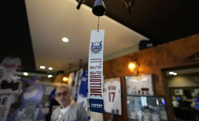 Hironobu Kanno, representative of a private fan club of Shohei Ohtani of the Los Angeles Dodgers, speaks near a Nambu cast iron wind chime, one of famed local products, at his beauty salon in Oshu, northeastern Japan, the hometown of Ohtani, Tuesday, Oct. 29, 2024. (AP Photo/Eugene Hoshiko)