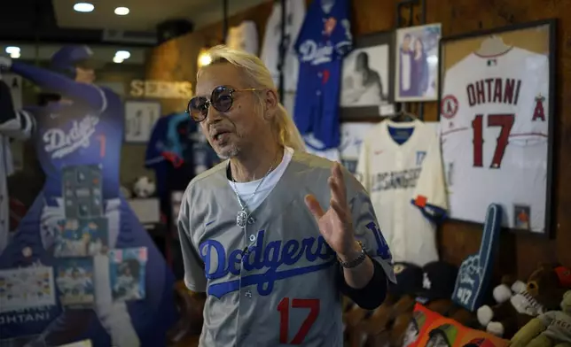 Hironobu Kanno, representative of a private fan club of Shohei Ohtani of the Los Angeles Dodgers, speaks surrounded by his collection goods of Ohtani at his beauty salon in Oshu, northeastern Japan, the hometown of Ohtani, Tuesday, Oct. 29, 2024. (AP Photo/Eugene Hoshiko)