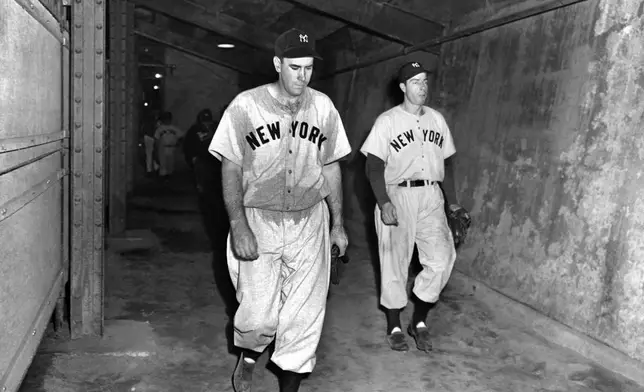 FILE - New York Yankees pitcher Bill Bevens, left, who pitched a one-hitter and lost, 3-2, and Yankees outfielder Joe DiMaggio walk down the runway leading to the clubhouse at Ebbets Field after Game 4 of the World Series against the Brooklyn Dodgers, Oct. 3, 1947. (AP Photo/John Lindsay, File)