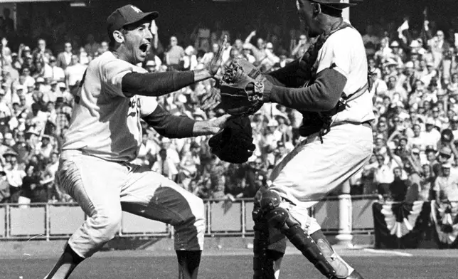 Pitcher Sandy Koufax, left, and catcher John Roseboro celebrate on the field in Los Angeles, Ca., Oct. 6,1963, after the Los Angeles Dodgers beat the New York Yankees 2-1 to take the 1963 World Series in four straight games. (AP Photo/File)