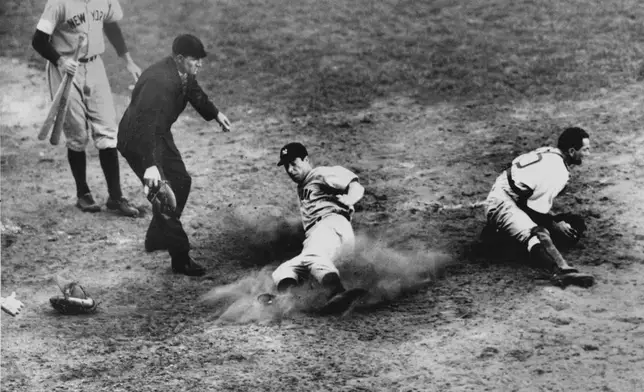 FILE - New York Yankees outfielder Joe DiMaggio (5) slides home safely in the ninth inning to score his team's fifth and winning run in Game 4 of the World Series against the Brooklyn Dodgers at Ebbets Field, Brooklyn, N.Y., Oct. 5, 1941. Dodgers catcher Mickey Owen has the ball. The Yankees won 7 to 4. (AP Photo/Murray Becker, File)