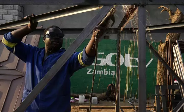 Tindor Sikunyongana welds using a diesel generator in Lusaka, Zambia, Monday, Sept. 16, 2024. (AP Photo/Themba Hadebe)