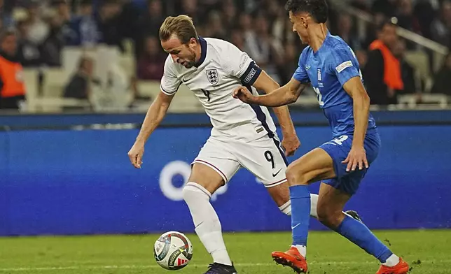 England's Harry Kane, left, and Dimitris Giannoulis of Greece, right, fight for the ball during the UEFA Nations League Group F soccer match between Greece and England at Olympic Stadium in Athens, Thursday, Nov. 14, 2024. (AP Photo/Petros Giannakouris)