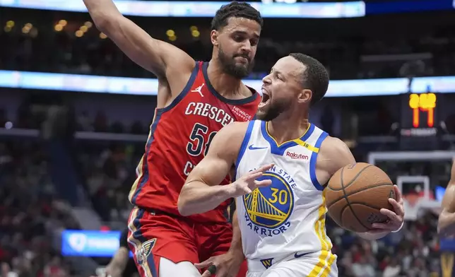 Golden State Warriors guard Stephen Curry (30) drives to the basket against New Orleans Pelicans center Trey Jemison III in the first half of an Emirates NBA Cup basketball game in New Orleans, Friday, Nov. 22, 2024. (AP Photo/Gerald Herbert)