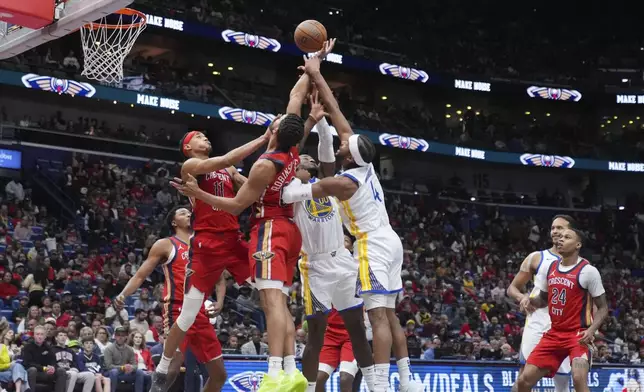 New Orleans Pelicans guard Brandon Boston Jr. (11) and center Trey Jemison III leap for a rebound against Golden State Warriors guard Moses Moody (4) and forward Jonathan Kuminga (00) in the first half of an NBA basketball game in New Orleans, Friday, Nov. 22, 2024. (AP Photo/Gerald Herbert)