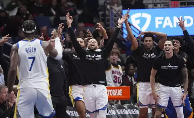 Golden State Warriors guard Stephen Curry reacts with the bench after guard Buddy Hield (7) made a 3-point basket in the second half of an an Emirates NBA Cup basketball game in New Orleans, Friday, Nov. 22, 2024. The Warriors won 108-112. (AP Photo/Gerald Herbert)