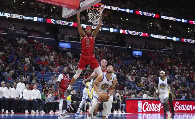 New Orleans Pelicans guard Brandon Boston Jr. (11) leaps to block Golden State Warriors guard Stephen Curry (30) in the first half of an NBA basketball game in New Orleans, Friday, Nov. 22, 2024. (AP Photo/Gerald Herbert)