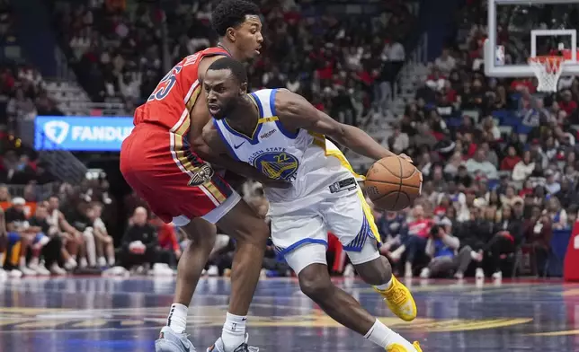 Golden State Warriors forward Andrew Wiggins (22) drives to the basket against New Orleans Pelicans guard Trey Murphy III in the first half of an NBA basketball game in New Orleans, Friday, Nov. 22, 2024. (AP Photo/Gerald Herbert)