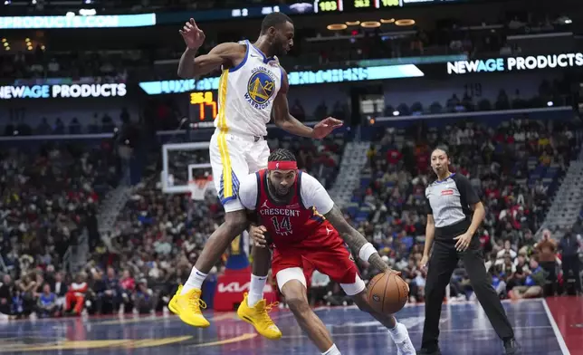 New Orleans Pelicans forward Brandon Ingram (14) is fouled by Golden State Warriors forward Andrew Wiggins (22) as he drives to the basket in the second half of an an Emirates NBA Cup basketball game in New Orleans, Friday, Nov. 22, 2024. The Warriors won 108-112. (AP Photo/Gerald Herbert)