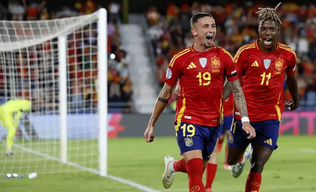 Spain's Yeremy Pino, left, celebrates with Niko Williams the opening goal during a Nations League soccer match between Spain and Switzerland, at the Heliodoro Rodríguez López stadium in Tenerife, Spain, Monday, Nov. 18, 2024. (AP Photo/Angel Fernandez)