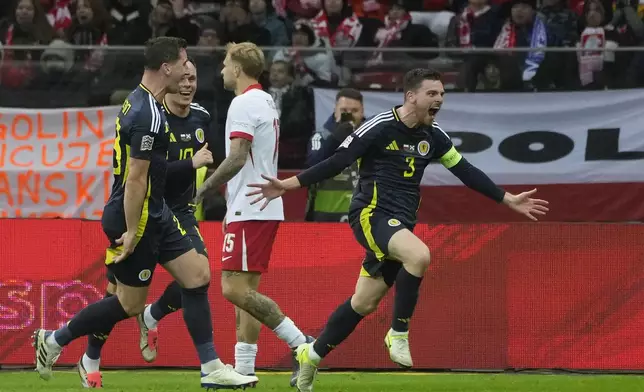 Scotland's Andy Robertson, right, celebrates with his teammates after scoring the second goal during the Nations League soccer match between Poland and Scotland at Narodowy stadium in Warsaw, Poland, Monday, Nov. 18, 2024. (AP Photo/Czarek Sokolowski)