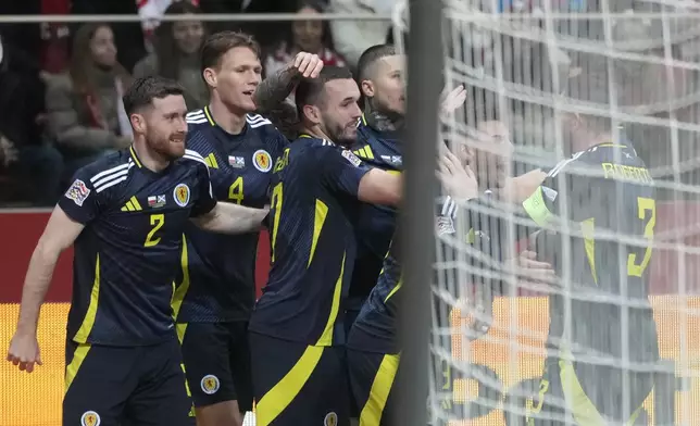 Scotland's John McGinn, center, celebrates with his teammates after scoring the opening goal during the UEFA Nations League soccer match between Poland and Scotland at Narodowy stadium in Warsaw, Poland, Monday, Nov. 18, 2024. (AP Photo/Czarek Sokolowski)