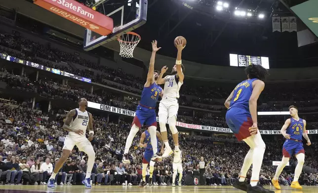 Dallas Mavericks guard Klay Thompson (31) shoots against Denver Nuggets forward Dario Saric (9) during the first half of an Emirates NBA Cup basketball game Friday, Nov. 22, 2024, in Denver. (AP Photo/Jack Dempsey)