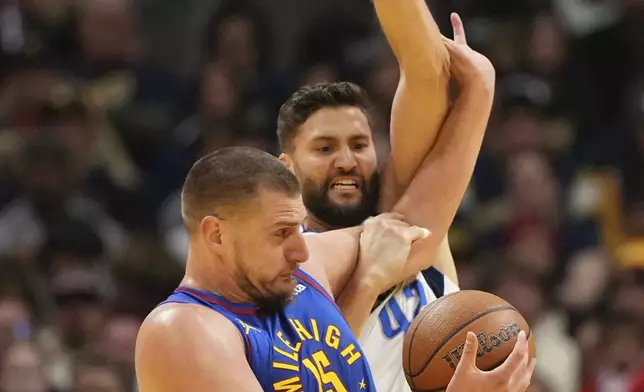 Denver Nuggets center Nikola Jokic (15) tangles with Dallas Mavericks forward Maxi Kleber, right, during the first half of an Emirates NBA Cup basketball game Friday, Nov. 22, 2024, in Denver. (AP Photo/Jack Dempsey)