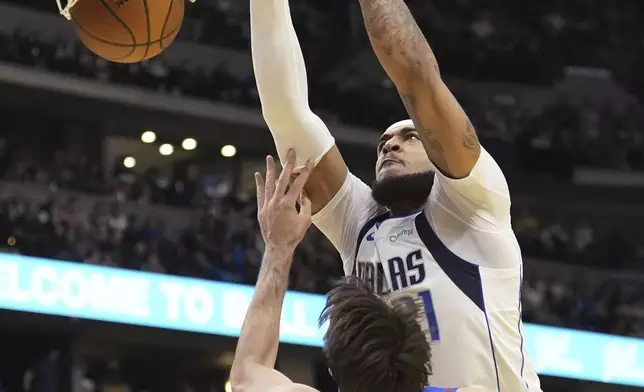 Dallas Mavericks center Daniel Gafford (21) dunks against Denver Nuggets forward Dario Saric (9) during the first half of an Emirates NBA Cup basketball game Friday, Nov. 22, 2024, in Denver. (AP Photo/Jack Dempsey)