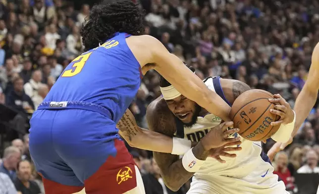 Dallas Mavericks guard Jaden Hardy (1) is fouled by Denver Nuggets guard Julian Strawther (3) during the first half of an Emirates NBA Cup basketball game Friday, Nov. 22, 2024, in Denver. (AP Photo/Jack Dempsey)