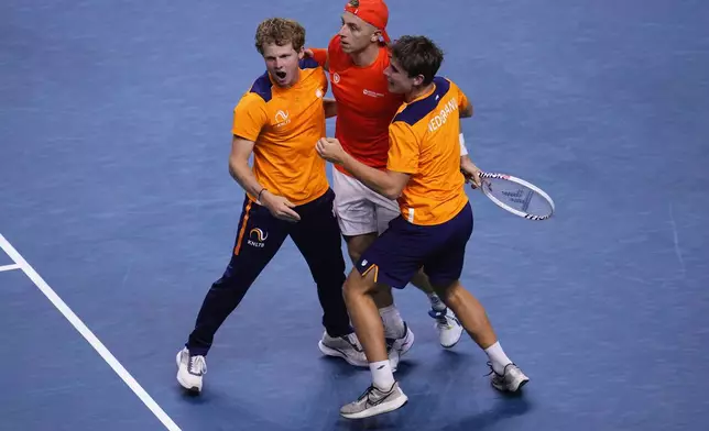 Netherlands' Tallon Griekspoor is congratulated by teammates after winning Germany's Jan-Lennard Struff during the Davis Cup semifinal at the Martin Carpena Sports Hall in Malaga, southern Spain, on Friday, Nov. 22, 2024. (AP Photo/Manu Fernandez)