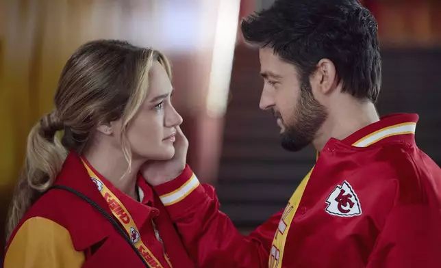 This image released by Hallmark Media shows Hunter King, left, and Tyler Hynes in a scene from "Holiday Touchdown: A Chiefs Love Story. (Joshua Haines/Hallmark Media via AP)