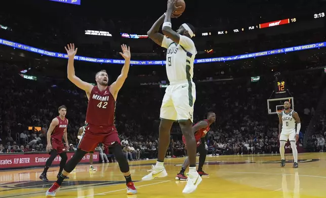 Milwaukee Bucks forward Bobby Portis (9) shoots as Miami Heat forward Kevin Love (42) defends during the first half of an Emirates NBA Cup basketball game, Tuesday, Nov. 26, 2024, in Miami. (AP Photo/Lynne Sladky)