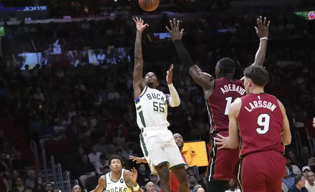 Milwaukee Bucks guard Delon Wright (55) shoots over Miami Heat center Bam Adebayo (13) during the first half of an Emirates NBA Cup basketball game, Tuesday, Nov. 26, 2024, in Miami. (AP Photo/Lynne Sladky)