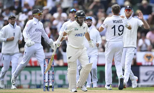 New Zealand's Tom Latham reacts after he was dismissed by England's Chris Woakes, second right, during play on the third day of the first cricket test between England and New Zealand at Hagley Oval in Christchurch, New Zealand, Saturday, Nov. 30, 2024. (Andrew Cornaga/Photosport via AP)