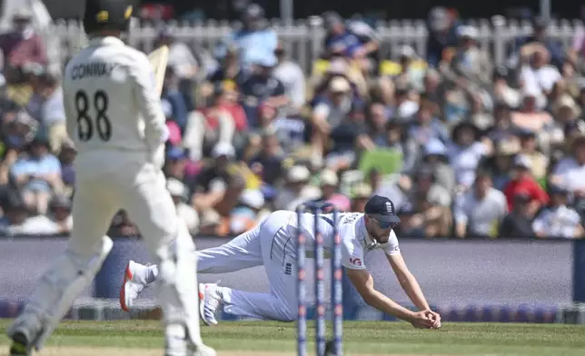 Gus Atkinson of England takes a catch to dismiss New Zealand's Devon Conway, left, during play on the third day of the first cricket test between England and New Zealand at Hagley Oval in Christchurch, New Zealand, Saturday, Nov. 30, 2024.(John Davidson/Photosport via AP)