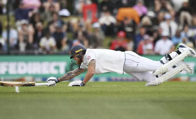 England's Ben Stokes dives to to make his ground during play on the third day of the first cricket test between England and New Zealand at Hagley Oval in Christchurch, New Zealand, Saturday, Nov. 30, 2024. (Chris Symes/Photosport via AP)