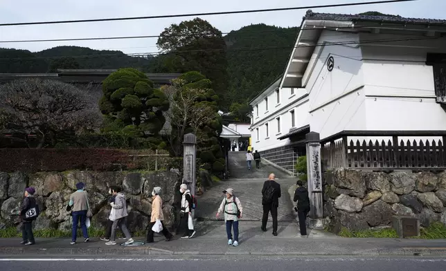 Visitors of Ozawa Sake Brewery leave as journalists enter the brewery on a media tour in Ome, on the western outskirts of Tokyo, Japan, Wednesday, Nov. 13, 2024. (AP Photo/Hiro Komae)