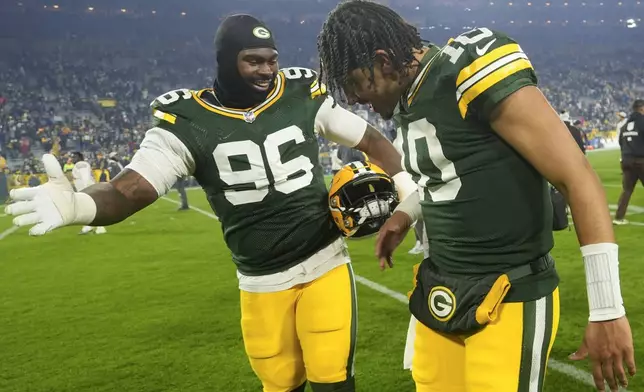 Green Bay Packers quarterback Jordan Love (10) and defensive tackle Colby Wooden (96) celebrate a win after an NFL football game against the San Francisco 49ers on Sunday, Nov. 24, 2024 in Green Bay, Wis. (AP Photo/Morry Gash)