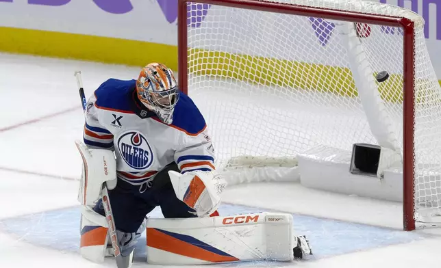 The puck bounces off the post behind Edmonton Oilers goaltender Stuart Skinner during the second period of an NHL hockey game in Ottawa, Tuesday, Nov. 19, 2024. No goal was scored on the play. (Adrian Wyld/The Canadian Press via AP)