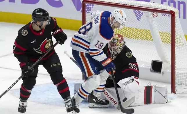 Ottawa Senators defenseman Nick Jensen looks on as goaltender Linus Ullmark battles for the puck with Edmonton Oilers left wing Zach Hyman during the first period of an NHL hockey game, Tuesday, Nov. 19, 2024 in Ottawa, Ontario. (Adrian Wyld/The Canadian Press via AP)