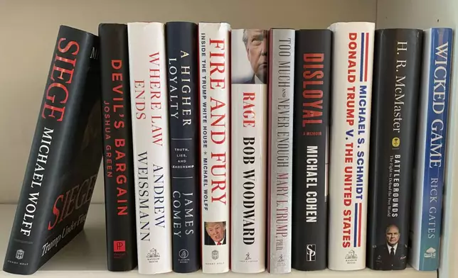 FILE - A collection of books about President Donald Trump, from left, "Siege" by Michael Wolff, "Devil's Bargain" by Joshua Green, "Where Law Ends" by Andrew Weissmann, "A Higher Loyalty: Truth, Lies, and Leadership" by James Comey, "Fire and Fury: Inside the Trump White House" by Michael Wolff, "Rage" by Bob Woodward, "Too Much and Never Enough" by Mary L. Trump, "Disloyal" by Michael Cohen, "Donald Trump V. The United States" by Michael S. Schmidt, "Battlegrounds: The Fight to Defend the Free World" by H. R. McMaster and "Wicked Game" by Rick Gates appear on a shelf in Westchester County, N.Y. on Monday, Nov. 9, 2020. (AP Photo, File)