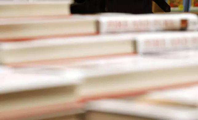 FILE - A customer looks at a copy of Michael Wolff's "Fire and Fury: Inside the Trump White House" as they go on sale at a bookshop, in London, Tuesday, Jan. 9, 2018. (AP Photo/Alastair Grant, File)